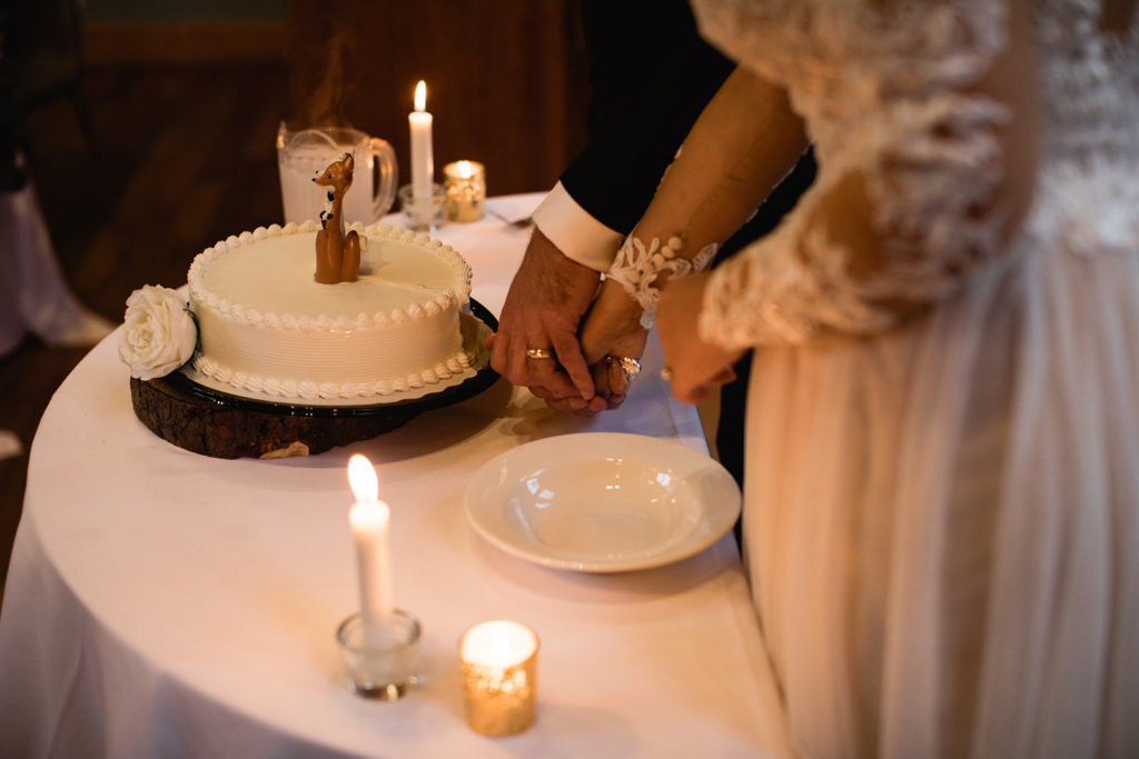 Couple cuts wedding cake at Emerald Lake Lodge wedding. 